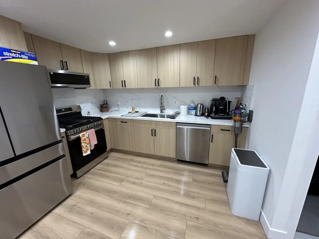 Modern kitchen with light wood cabinetry and marble countertops after cleaning