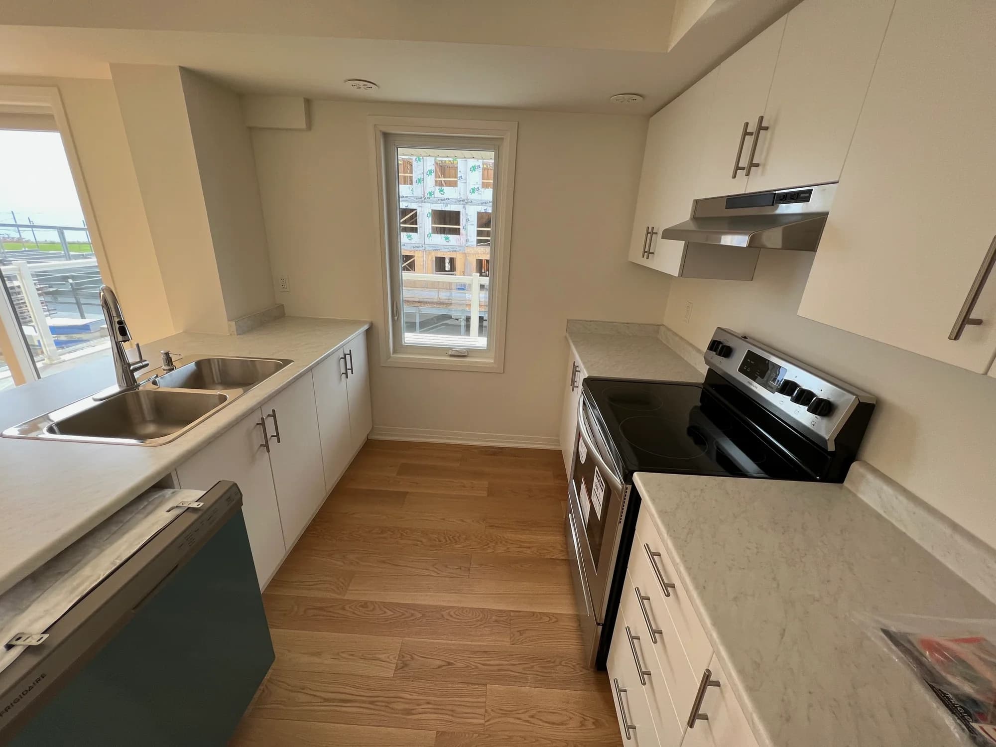 New-build white kitchen with marble countertops and stainless steel appliances after move-in cleaning