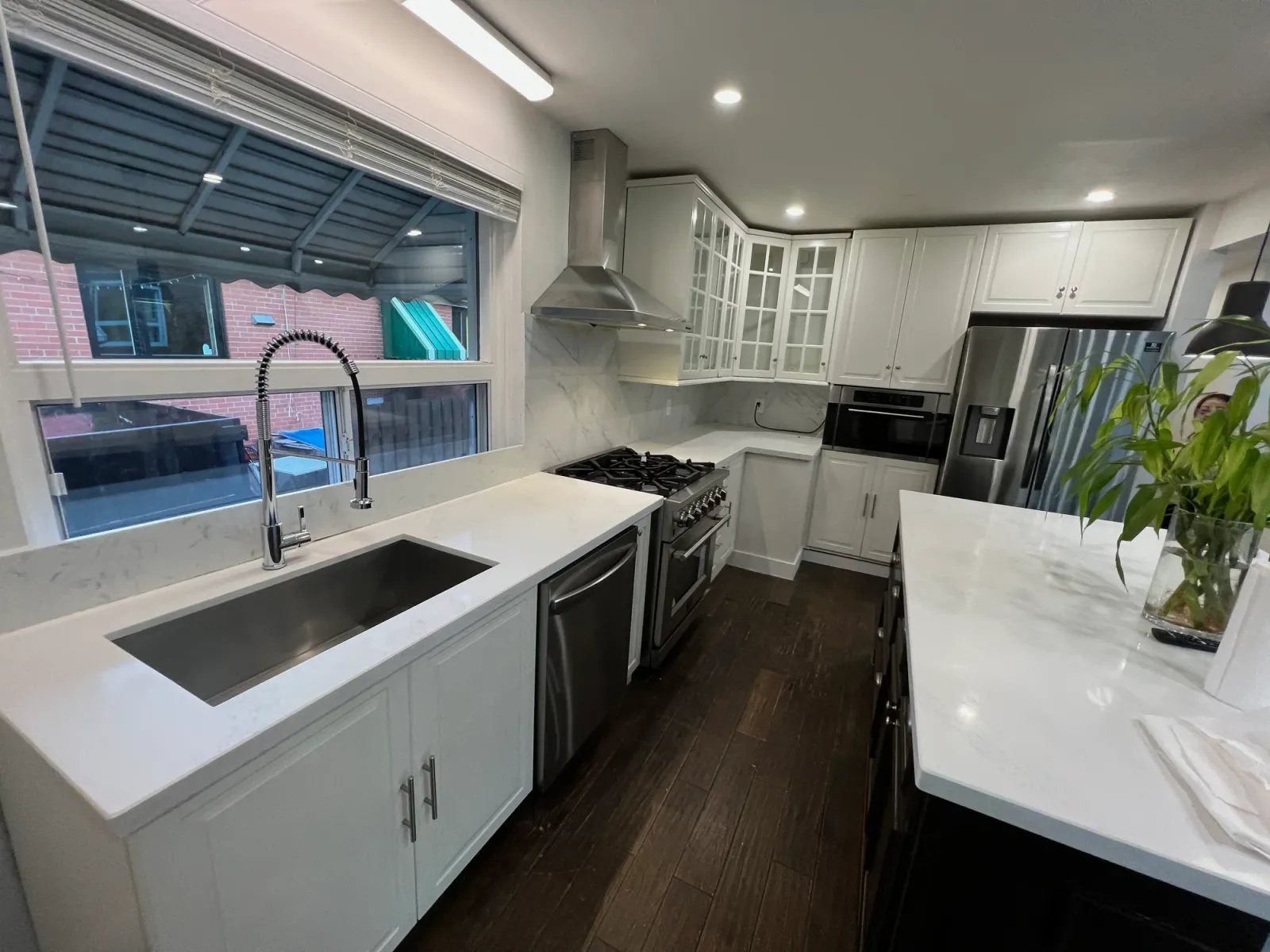 White marble kitchen with stainless steel appliances and island after deep cleaning