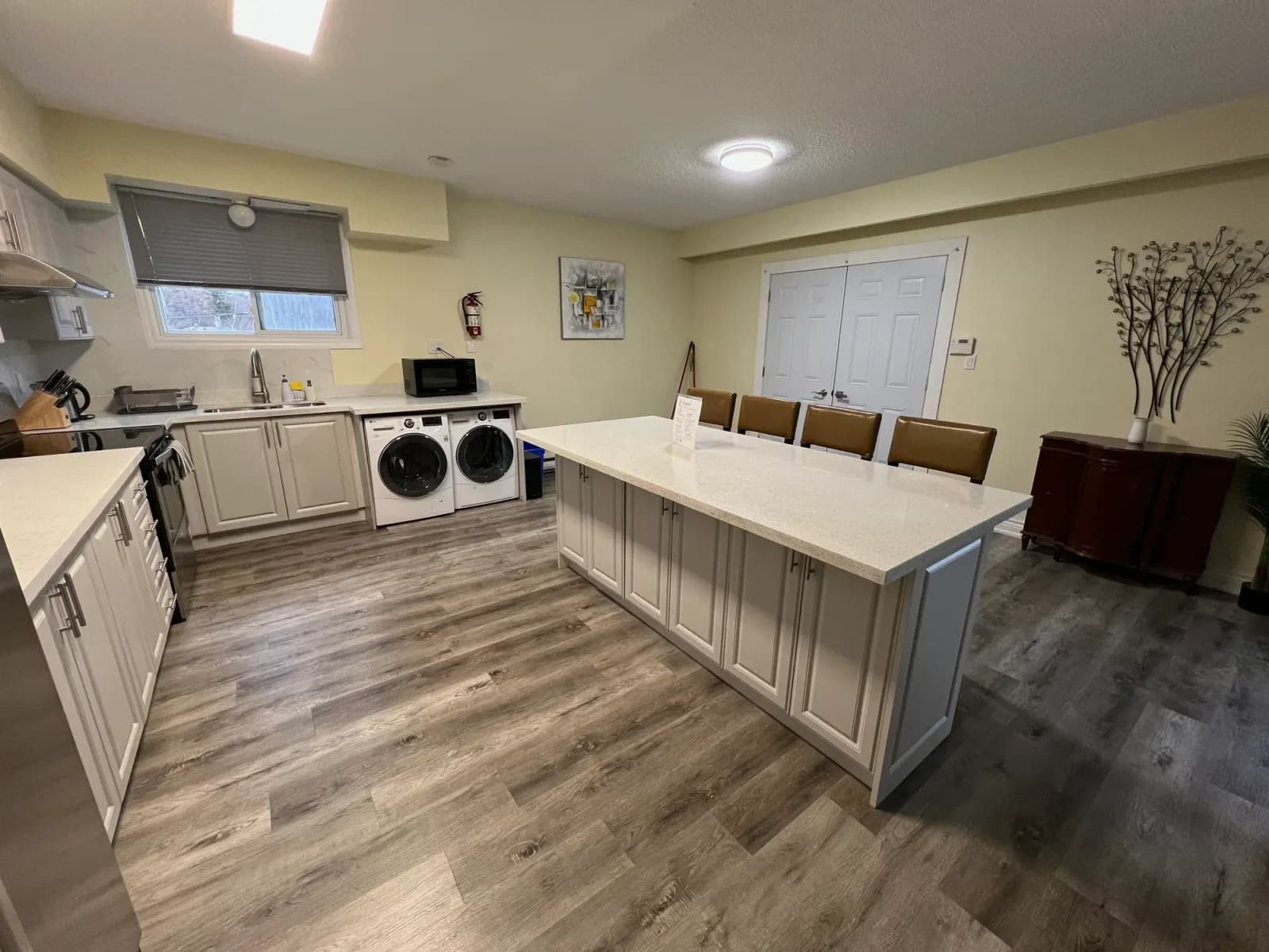 Open-plan kitchen and living area with island seating and integrated laundry after residential cleaning