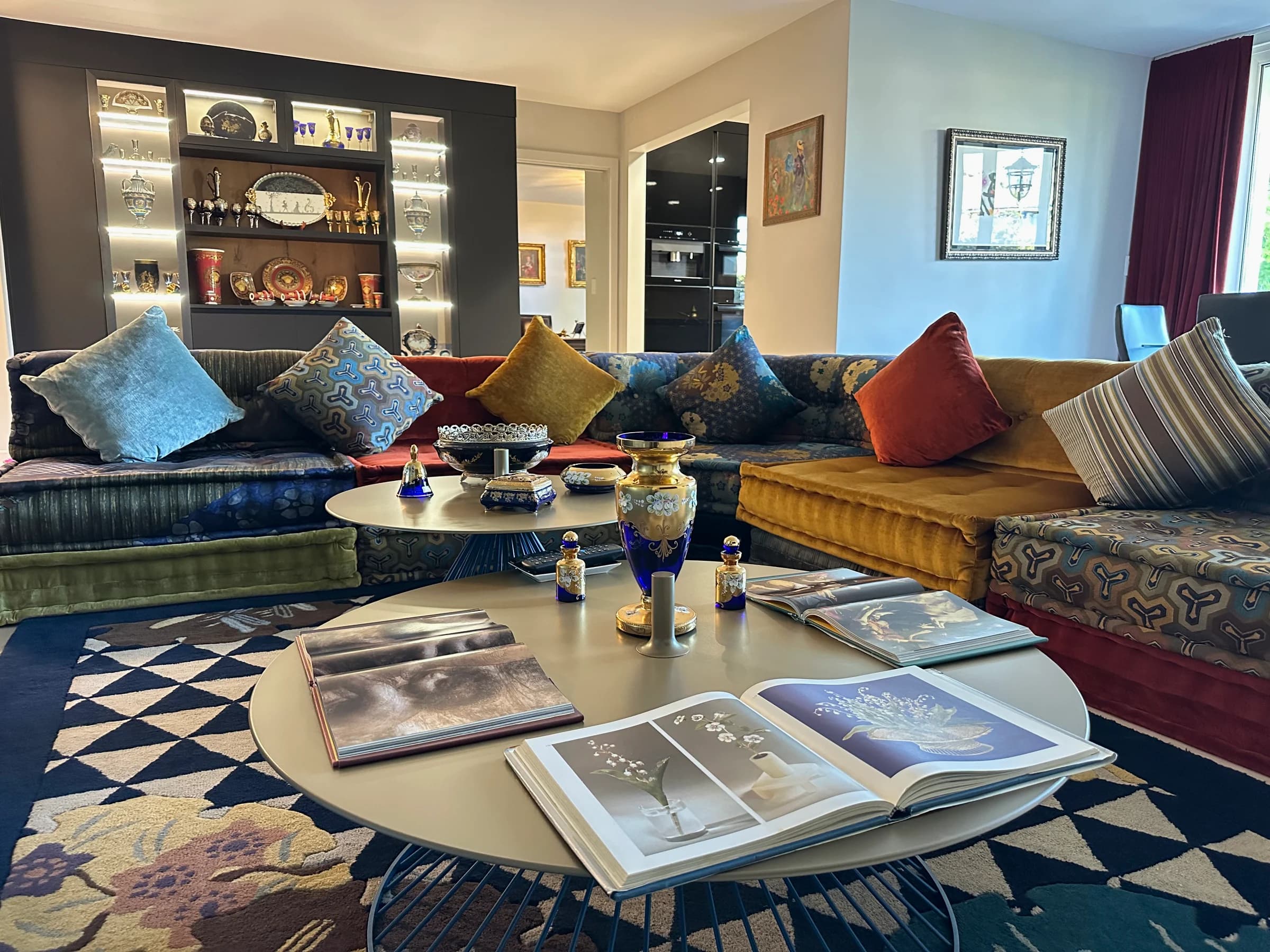 Eclectic living lounge with statement sectional, built-in display, and polished surfaces after deep cleaning