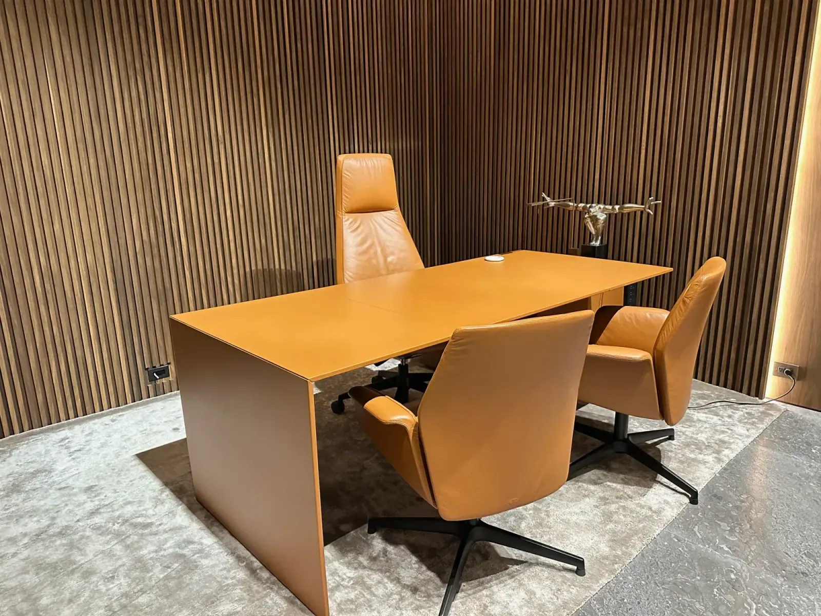 Executive office with leather seating and wood slat walls after office cleaning